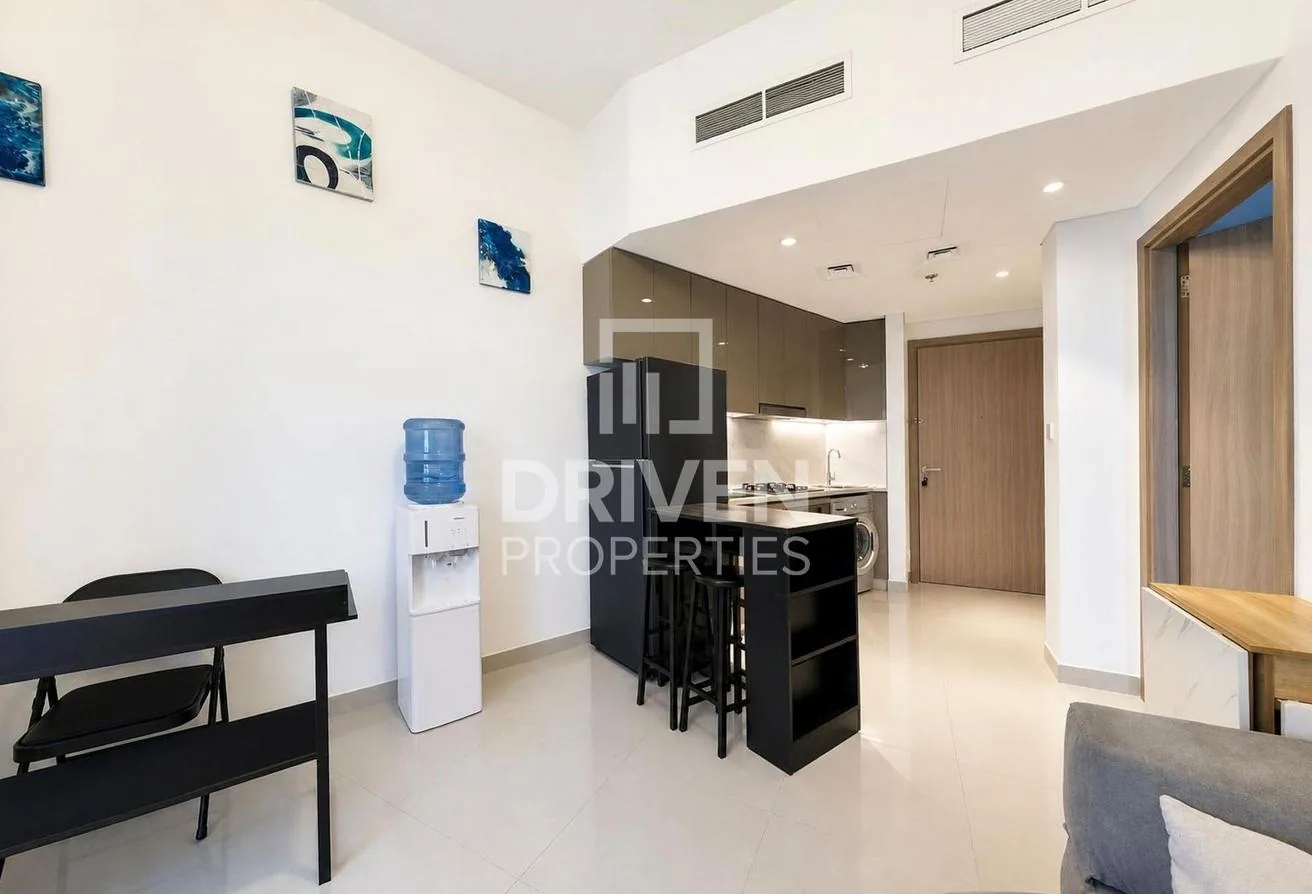 Open-plan living and kitchen with a breakfast bar at the Azizi Gardens apartment