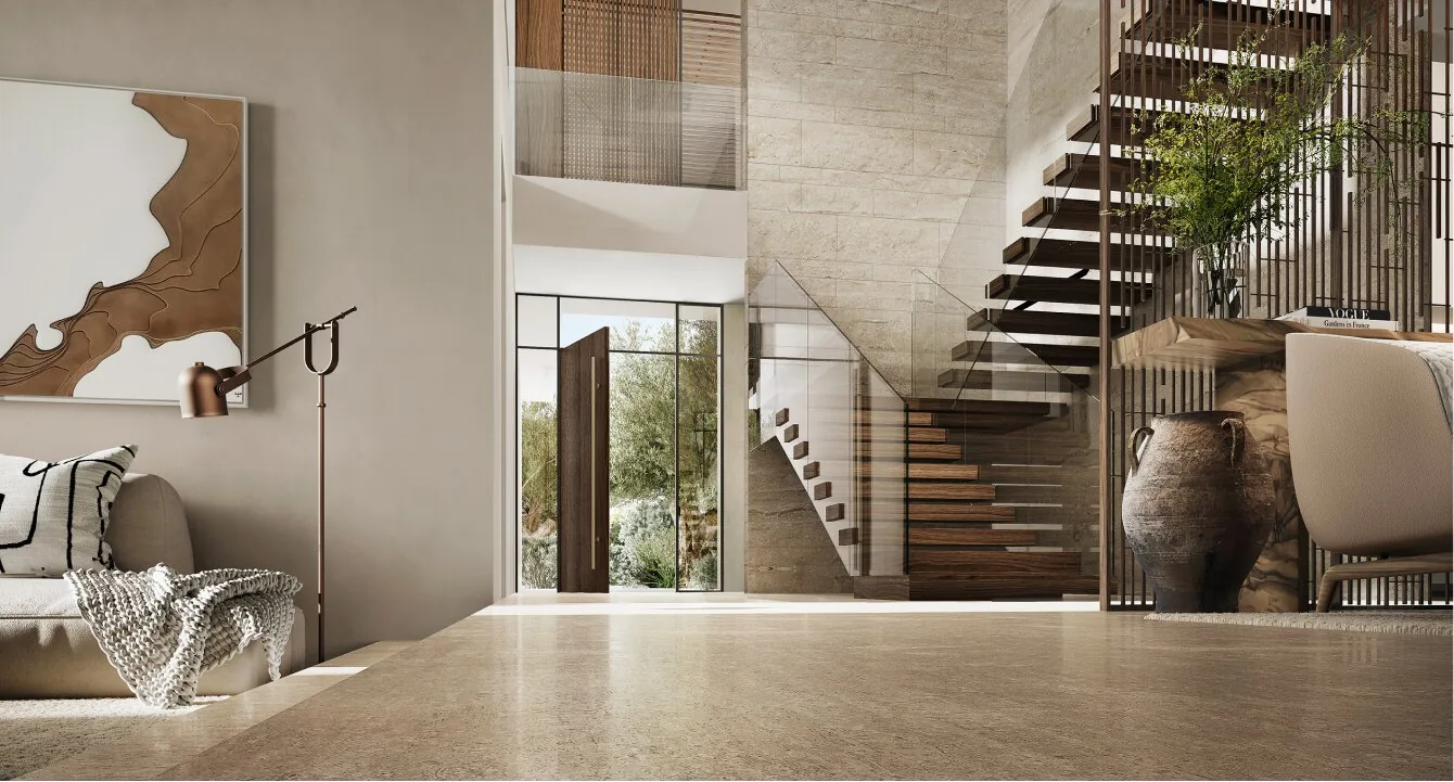 Double height entrance hall at Alaya Beach with a floating timber staircase and travertine floors