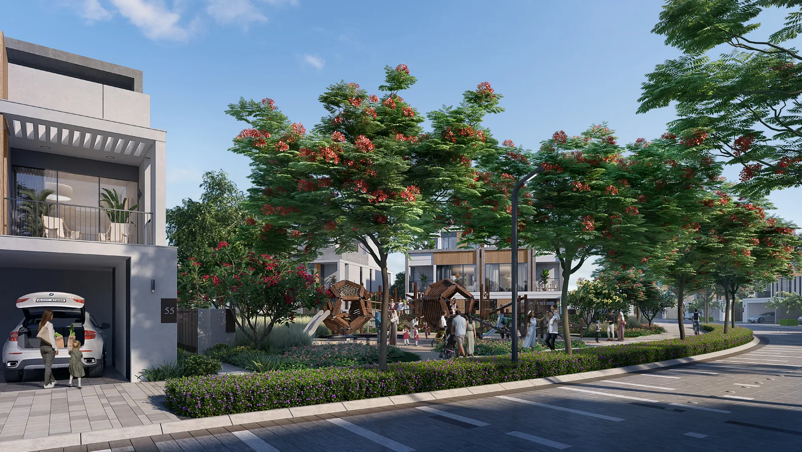 Street in Aura, Tilal Al Ghaf lined with twin villas and flowering trees, with a children's play area across the road
